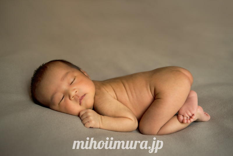 ポーズドニューボーンフォト　新生児の赤ちゃんがシーツに横になっている