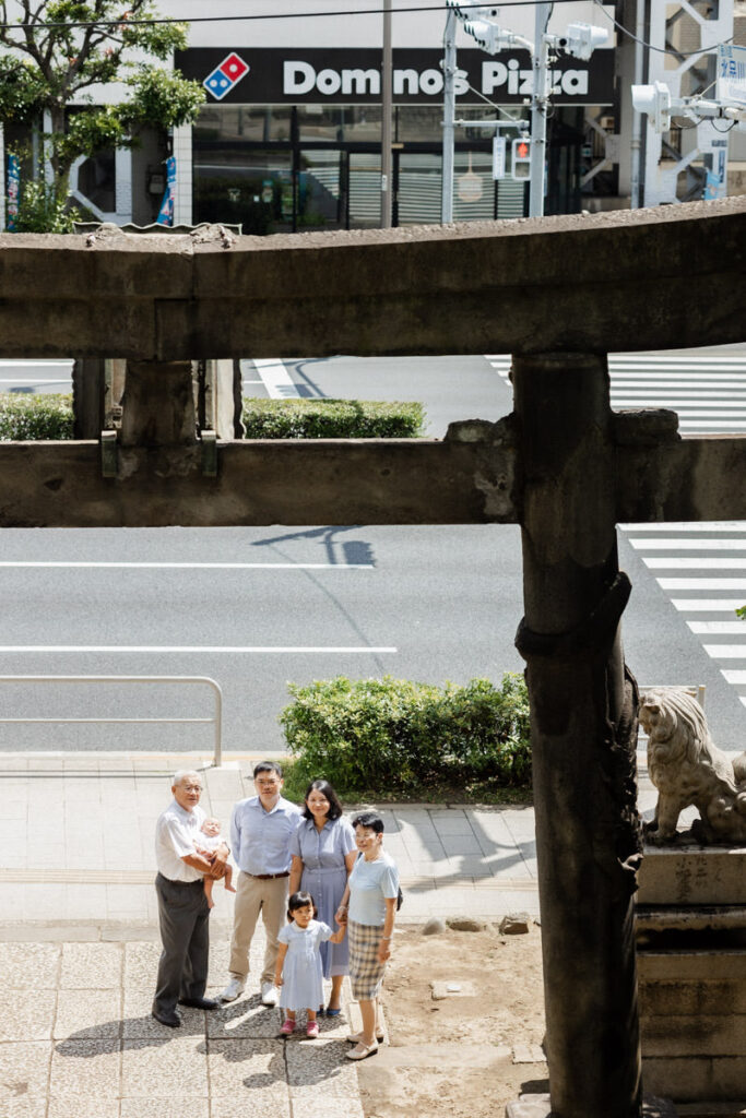 品川神社の一の鳥居越しにお宮参りの記念写真